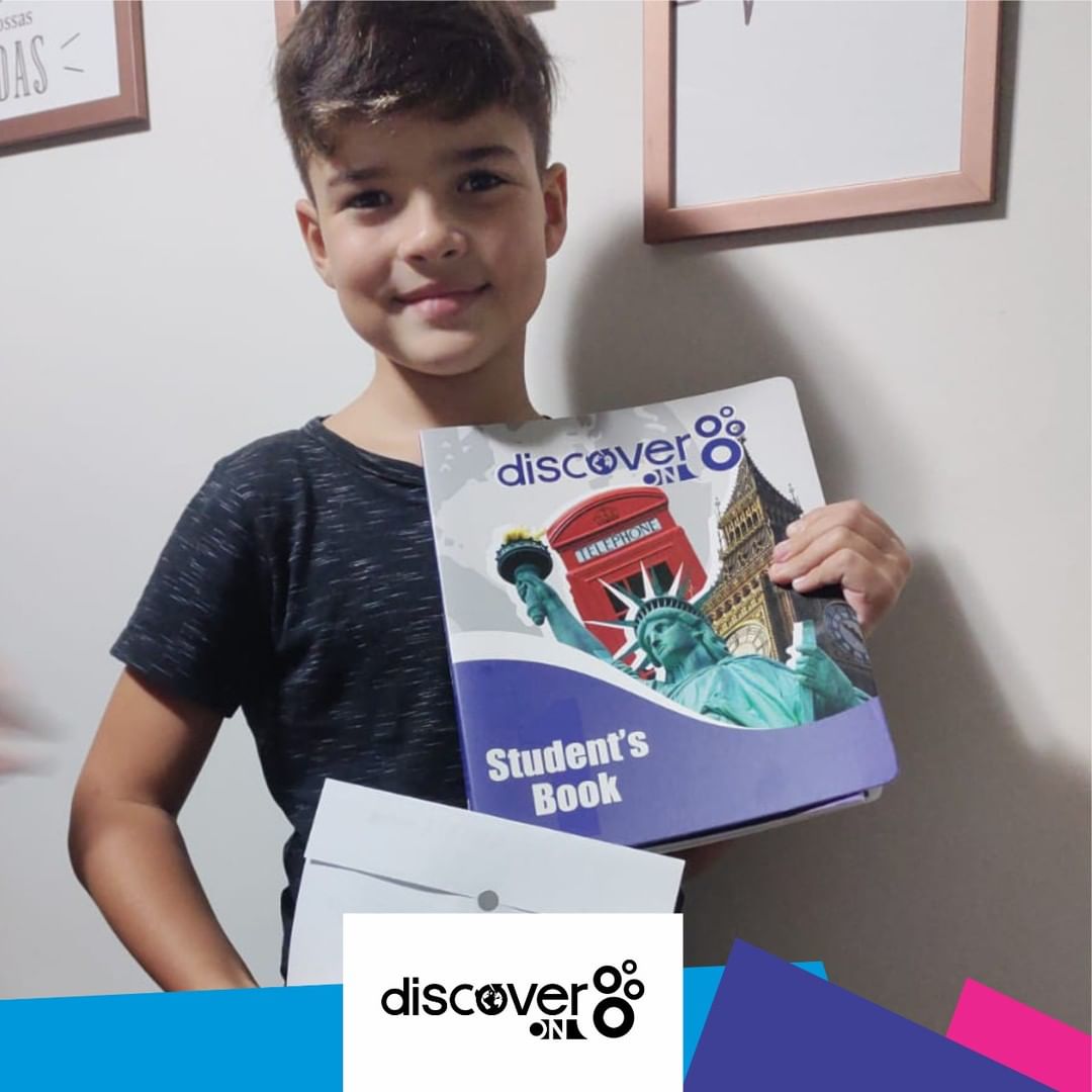 Aluno DiscoverON Segurando o Livro de Inglês